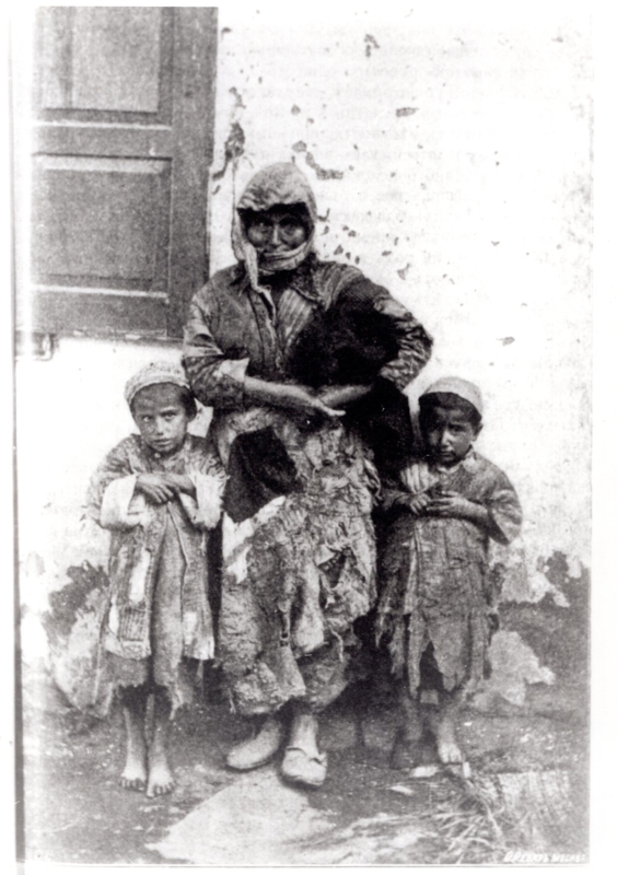 Ցնցոտիներով կինը երեխաների հետ