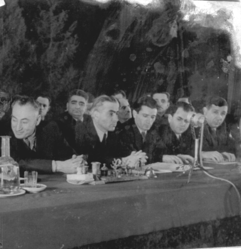 Մի խումբ  մարդիկ  ինչ – որ հանդիսավոր նիստի նախագահությունում: Ձախից առաջինը Գրիգոր Հարությունյան /Կենտկոմի առաջին քարտուղար/, աջից առաջինը՝ Մացակ Պապյան, երկրորդը՝  Փիրուզյան:  Երկրորդ շարքում ձախից երկրորդը Ղևոնդյան, 1940- 50 - ականներ