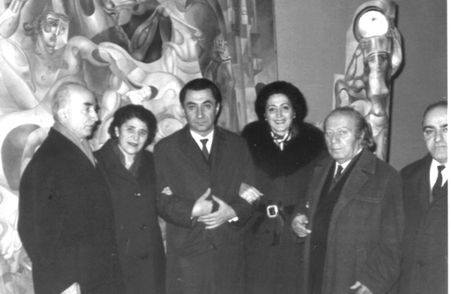 Ե. Քոչարը /ձախից երկրորդը/, կինը՝ Մանիկ Մկրտչյանը /ձախից հինգերորդը/, Գրիգոր Հասրաթյանը /ձախից չորրորդը/, կանադահայ լուսանկարիչ Գավուկի կինը /ձախից երրորդը/ և  ևս երկու տղամարդ, Քոչարի աշխատանքների ֆոնին, Երևան, 1971  