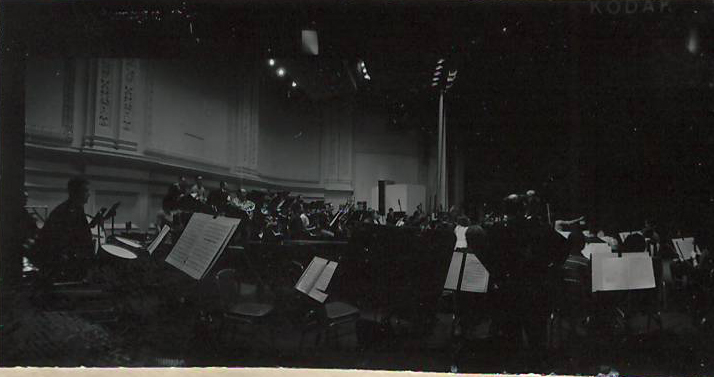Նեգատիվ՝ լուսանկարի. Ա. Խաչատրյանը Նյու Յորքի Քարնեգի Հոլ համերգասրահում՝ տեղի սիմֆոնիկ նվագախմբի հետ փորձի ժամանակ