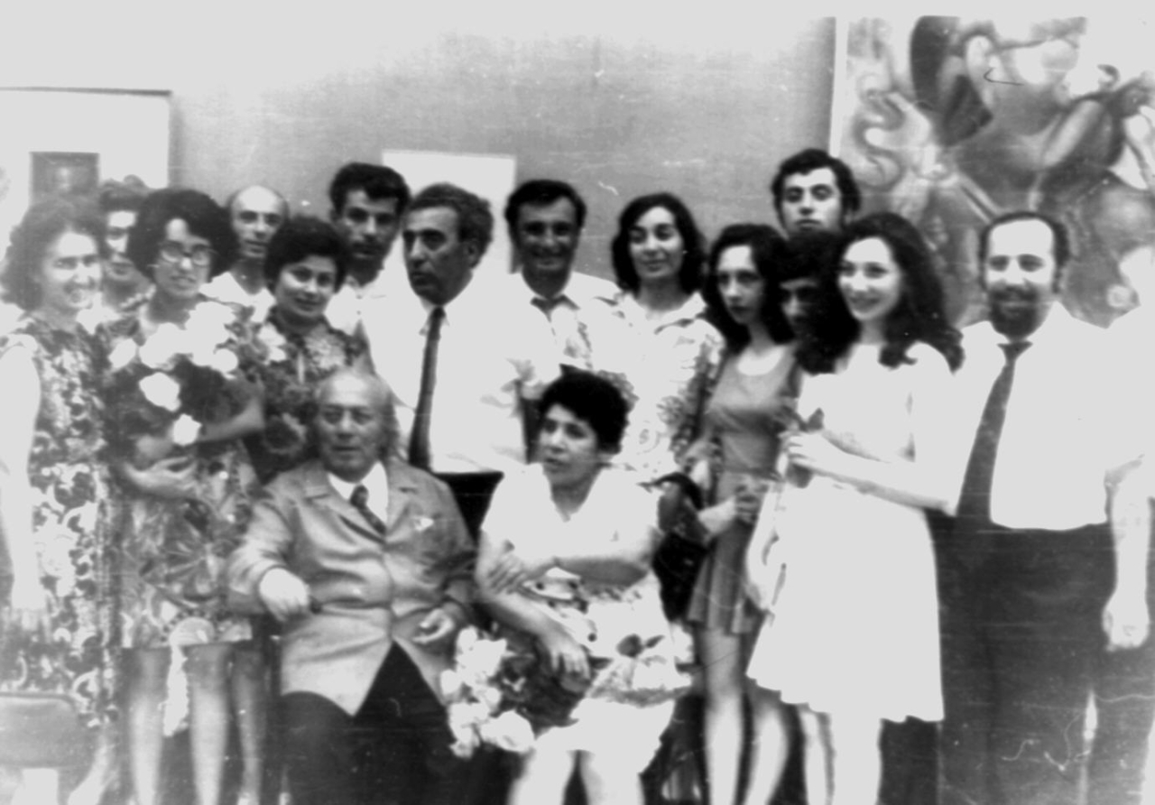 Ե. Քոչարը /նստած/,  կինը՝ Մանիկ Մկրտչյանը /կողքինը/, որդիները՝ Հայկազը /աջից առաջինը / և Ռուբիկը /աջից երրորդը/, հարսը՝  Լալա Մարտիրոսյանը /աջից երկրորդը/, Քոչարի բարեկամները  և մի խումբ այլ մարդիկ,  Թբիլիսի,1974